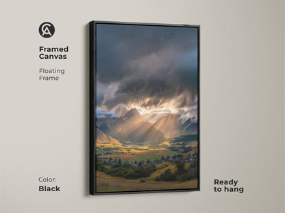Framed canvas of a mountain valley art print. Golden hour landscape with dramatic sun rays. Floating frame in black adds a modern touch. Ready to hang scenic village artwork for contemporary home decor.