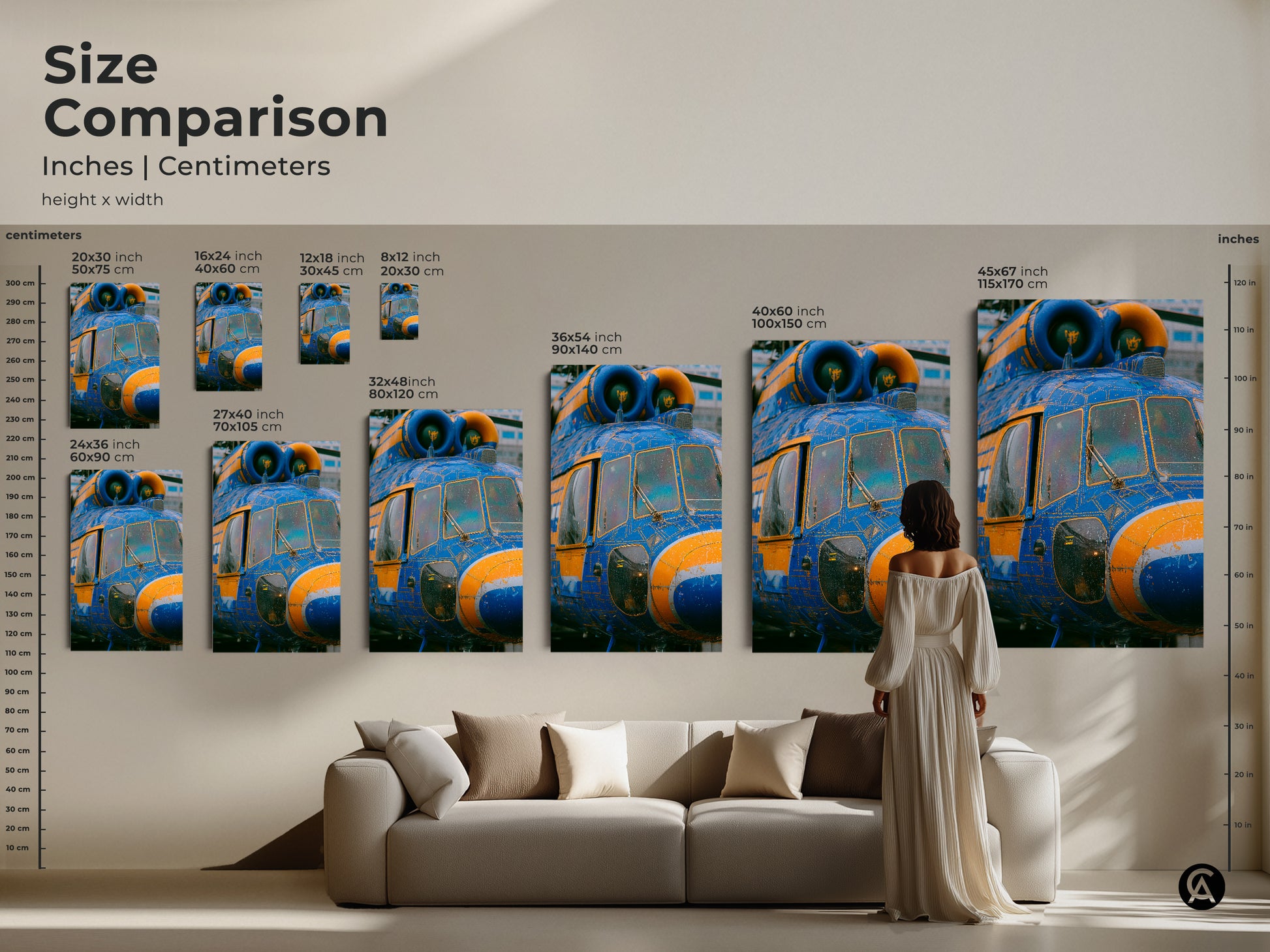 Size comparison of helicopter art prints. Inches and centimeters are shown. A woman in a dress is standing next to the artwork to show scale. The artwork is displayed above a couch.
