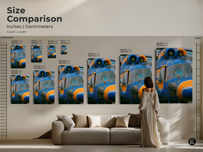 Size comparison of helicopter art prints. Inches and centimeters are shown. A woman in a dress is standing next to the artwork to show scale. The artwork is displayed above a couch.