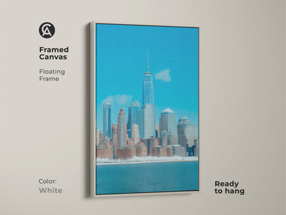 Framed canvas print of the New York City skyline in a modern blue palette. This contemporary architectural artwork features a white floating frame. Ready to hang adding an urban touch to decor.