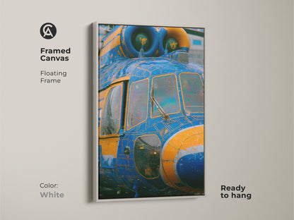 Framed canvas art featuring a blue and yellow helicopter. The floating frame is white. This unique piece of art is ready to hang. The helicopter artwork is printed on a framed canvas.