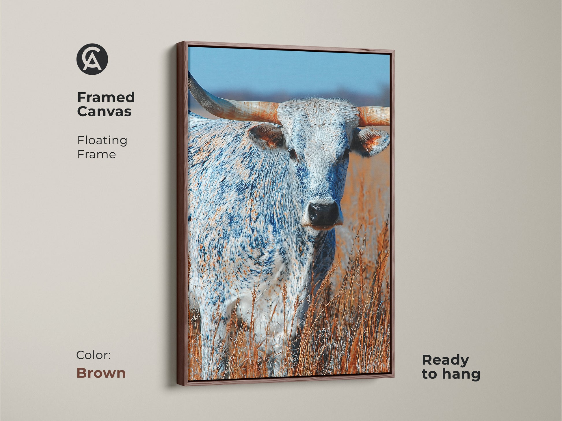 This framed canvas art features a longhorn bull. The artwork has a floating frame. The frame color is brown. This canvas print is ready to hang. The animal art is a beautiful addition to any space.