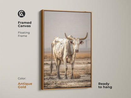 A framed canvas displays a floating antique gold frame. The cream and brown bull art is ready to hang. This bull portrait wall art enhances any space. The rustic cow wall decor is perfect for farmhouse decor. It's a stunning western cattle canvas.