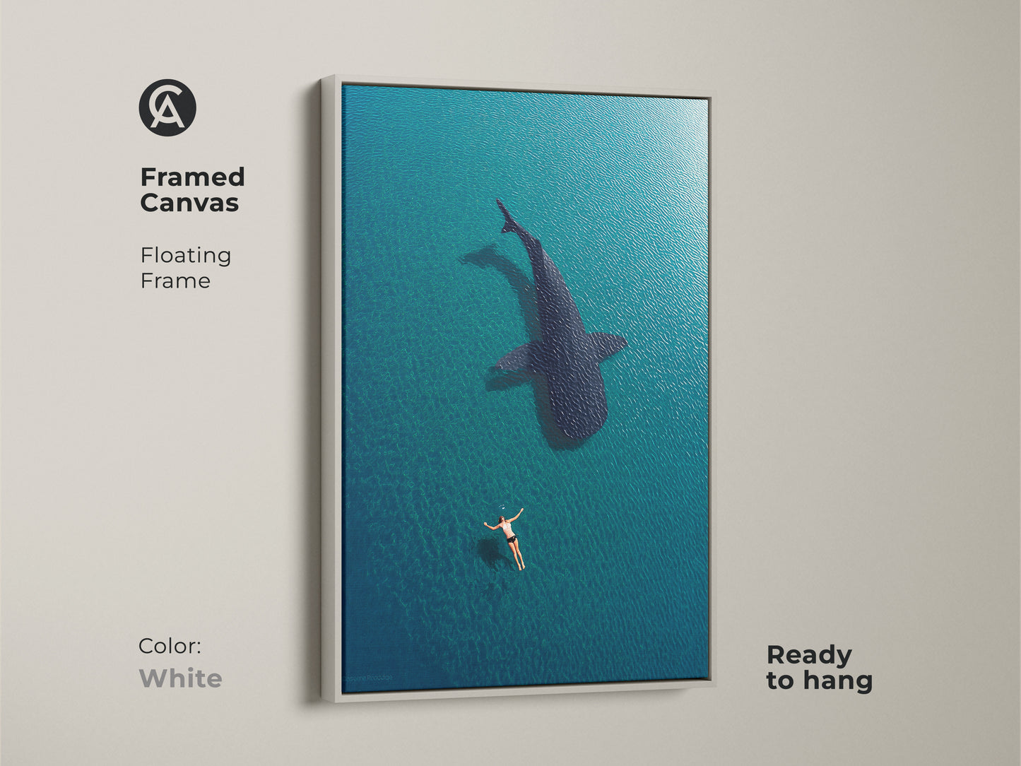 White framed canvas featuring aerial ocean art of a swimmer and whale shark. This ready-to-hang coastal artwork brings a fresh touch to your home. The deep blue turquoise tones create a calming underwater scene perfect for any modern decor.