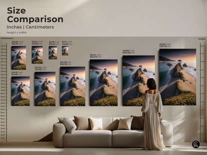 Size comparison of coastal artwork in inches and centimeters. Visualize various canvas sizes above a sofa. Featuring ocean sunset wall art and a lone tree beach print. Choose the perfect size for your space. Enhance your home with this rocky coast landscape artwork.