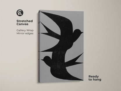 Stretched canvas art showing a minimalist black swallow flock. This abstract bird art is ready to hang. The gallery wrap has mirrored edges. It's a modern grey nature artwork that is perfect as bedroom wall art. This housewarming gift is a canvas that has a minimalist aesthetic.