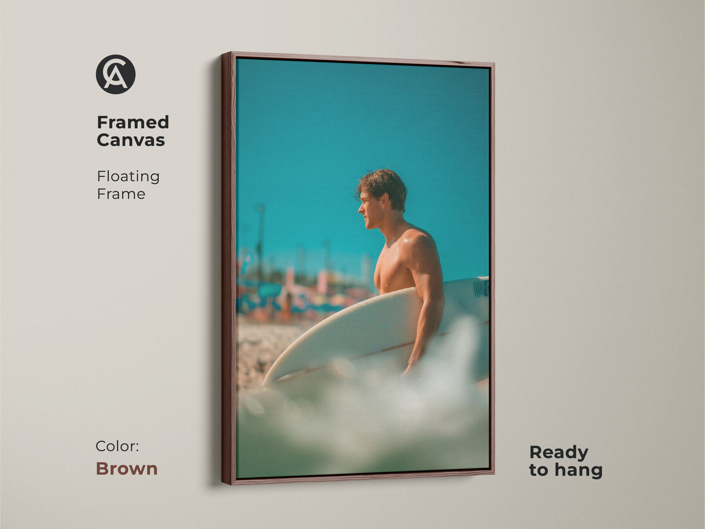 Framed canvas art featuring a surfer. The floating frame has a brown color. The image showcases a man holding a surfboard on a beach with a blue sky. This framed art is ready to hang.
