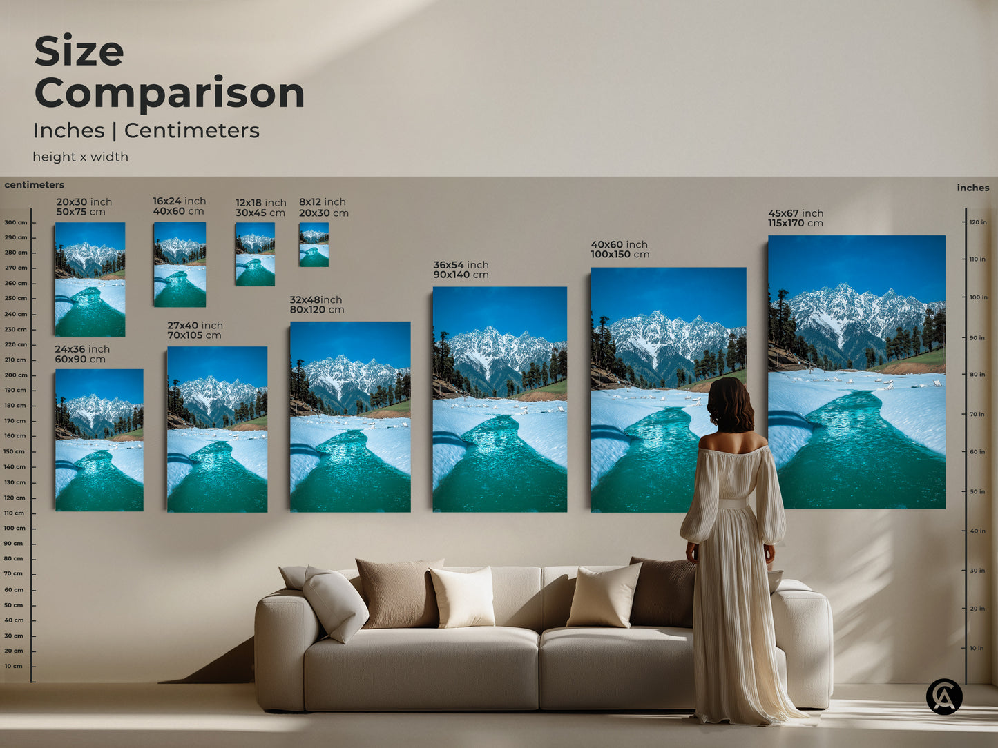 Size comparison of snowy mountain prints in inches and centimeters displayed above a sofa. Visualize how this blue nature photography fits into your living space. Perfect for adding a touch of winter wonderland to your modern home decor with realistic mountain art.