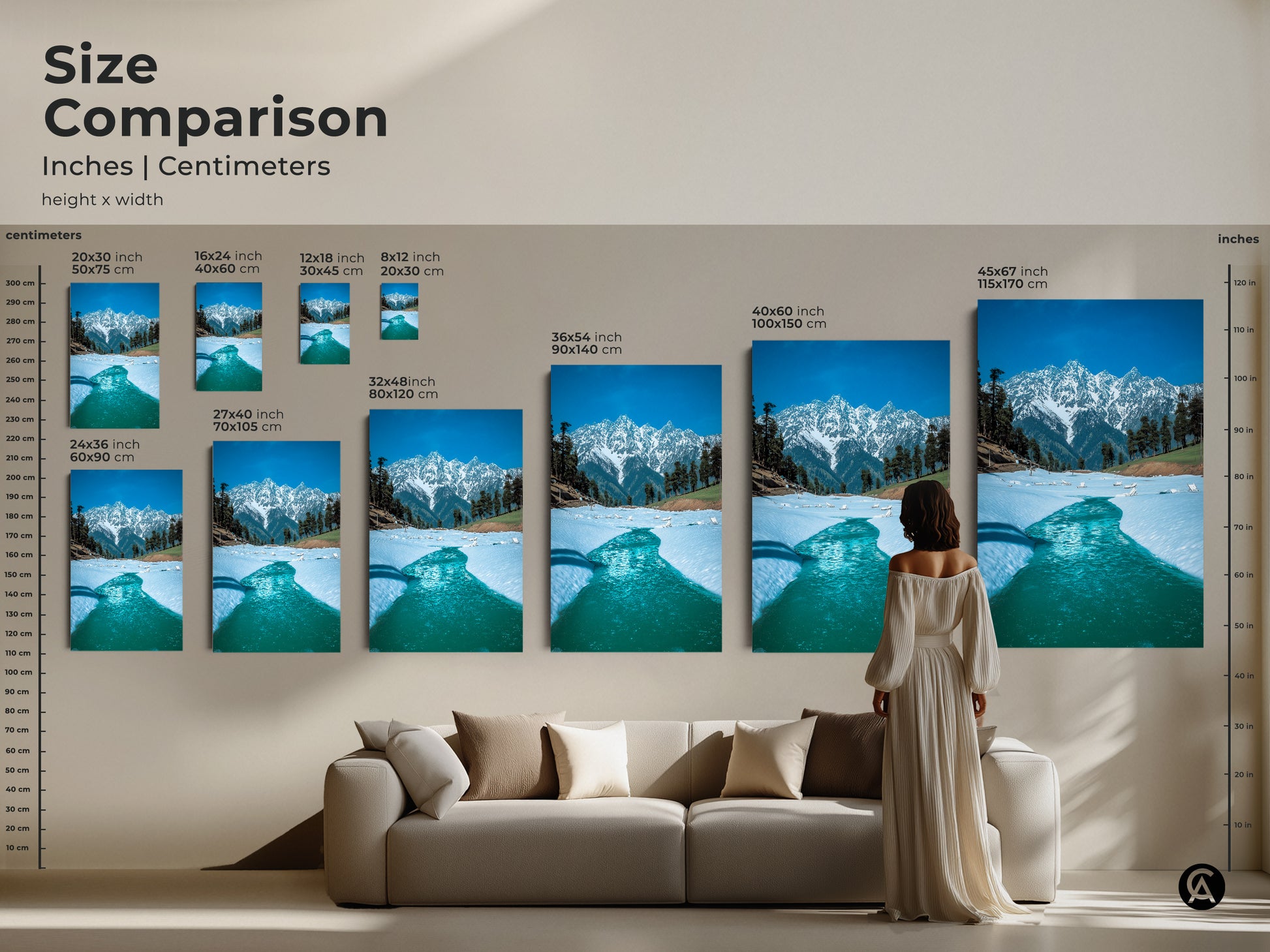Size comparison of snowy mountain prints in inches and centimeters displayed above a sofa. Visualize how this blue nature photography fits into your living space. Perfect for adding a touch of winter wonderland to your modern home decor with realistic mountain art.