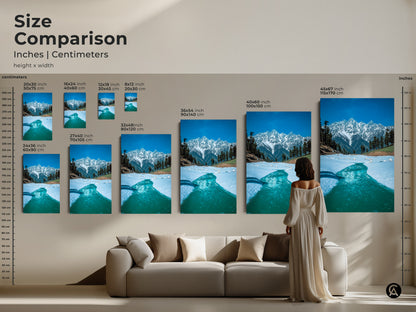 Size comparison of snowy mountain prints in inches and centimeters displayed above a sofa. Visualize how this blue nature photography fits into your living space. Perfect for adding a touch of winter wonderland to your modern home decor with realistic mountain art.