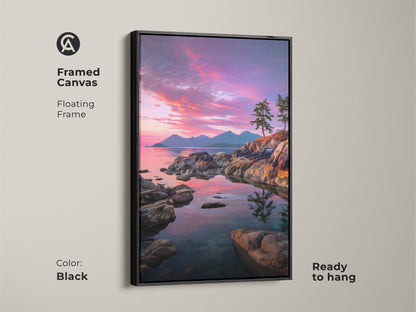 Framed canvas showcasing a coastal sunset ocean view. The black floating frame enhances the pink purple sky art. This rocky coastline wall art with pine trees is ready to hang. Ideal for adding a touch of nature to your bedroom or living room.