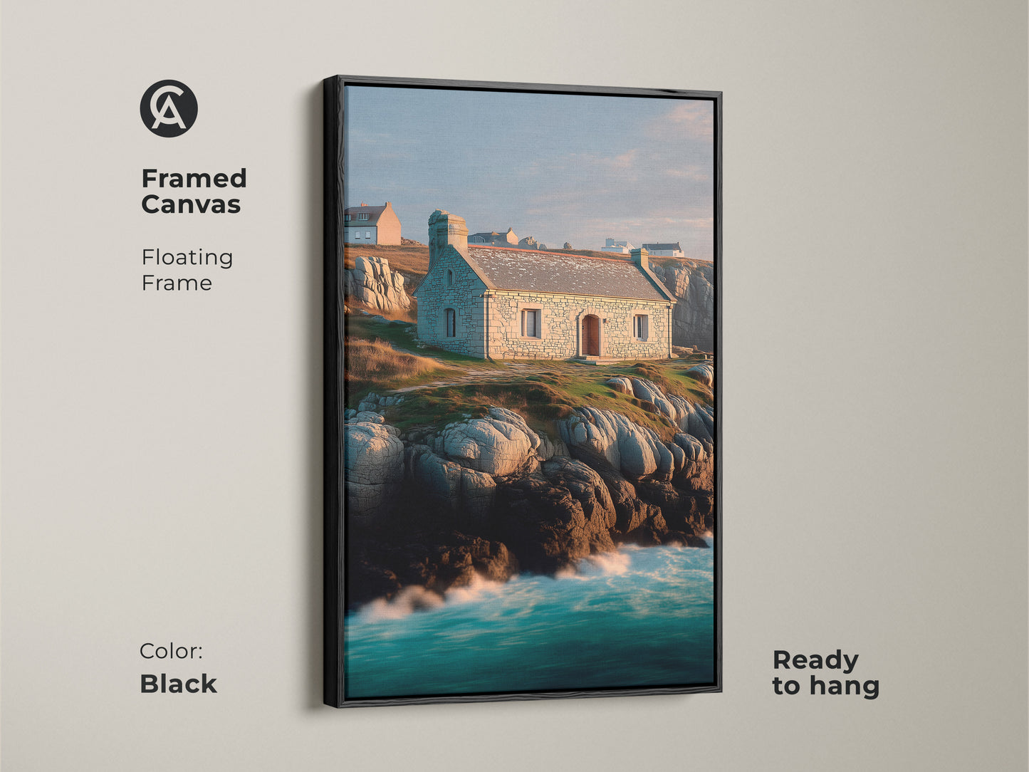 Framed canvas of a coastal stone cottage landscape. Floating frame in black finish enhances the ocean waves art. Realistic seascape featuring a stone house on a rocky coastline. Blue green teal colors create a calming coastal vibe. Ready to hang.