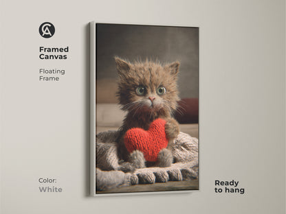 Framed canvas of a kitten holding a heart. This adorable cat canvas print has a floating frame in white. The warm tones make it perfect for adding a touch of love and comfort to any room. It's a cozy cat lover gift.