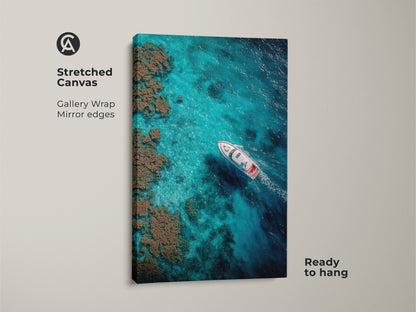 Stretched canvas gallery wrap photo art. The image shows a boat sailing through clear turquoise waters. Coral reefs are visible. This ready-to-hang artwork brings a touch of the ocean indoors.