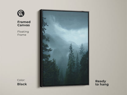 Framed canvas featuring dark green forest artwork. A floating frame in black enhances this blue mountain landscape. This moody pine trees artwork is ready to hang. Perfect nature home decor gift for a residential setting. The natural moody wall art complements any room.