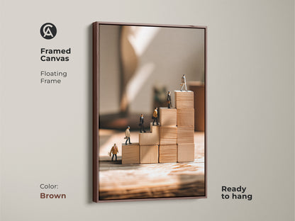 Framed canvas of miniature people ascending wooden blocks features a rich brown floating frame This motivational business artwork adds a sophisticated touch to any office The beige tan minimalist canvas print inspires success and career growth Ready to hang it makes an excellent entrepreneur gift for modern office wall decor A conceptual staircase artwork