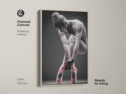 Framed canvas artwork featuring a ballerina. This canvas has a floating frame. The frame color is white. The art features a ballerina tying her pink ballet shoes. This framed art is ready to hang.