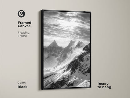 Framed canvas with monochrome mountain art. The snowy peaks canvas print features a floating black frame. This black and white landscape is ready to hang. Modern nature wall decor for a minimalist aesthetic.