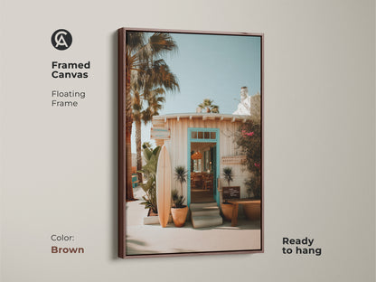 Framed canvas art with a floating brown frame presents a beach resort entrance. A surfboard accents the coastal theme. Ready to hang and enjoy. The brown frame complements the artwork's warm tones. Perfect for any room.