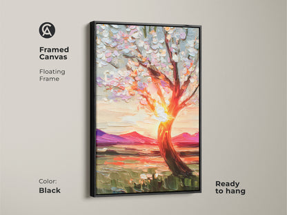 A framed textured canvas presents impressionist blooming tree artwork against a sunset. The black floating frame enhances the vibrant nature decor making it ready to hang. The orange yellow and pink landscape art adds a boho touch to a living room or home office a thoughtful gift.