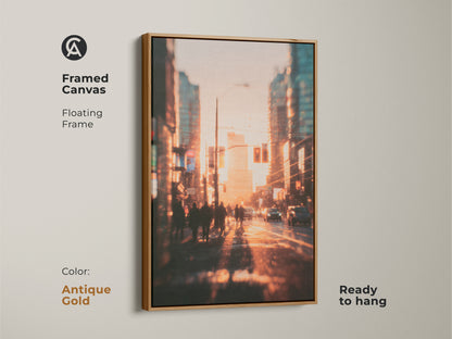 Framed canvas art showcasing a blurred urban landscape at sunset. The antique gold floating frame adds a touch of elegance. The artwork captures the energy of city life with pedestrians and cars. Ready to hang and transform your space with this beautiful piece.
