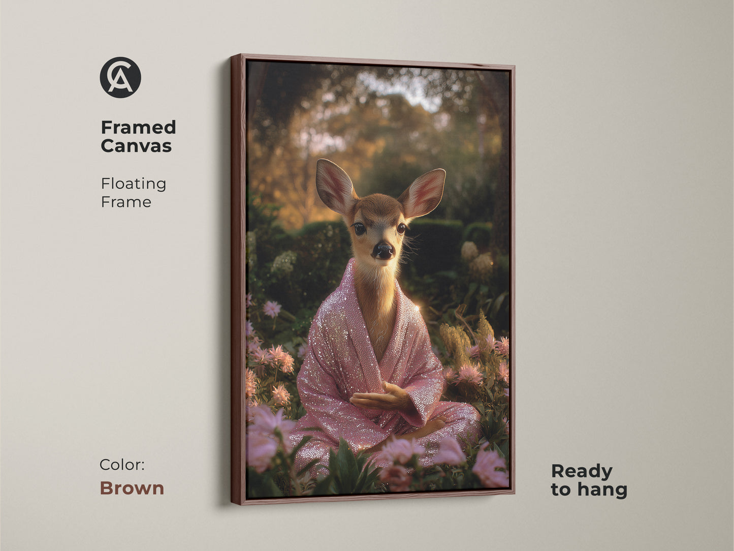 Brown framed canvas art featuring a meditating deer. The fawn is adorned with a pink sequin robe. This spiritual animal wall decor is ready to hang. The boho artwork brings peaceful nature vibes. It makes a unique housewarming gift.