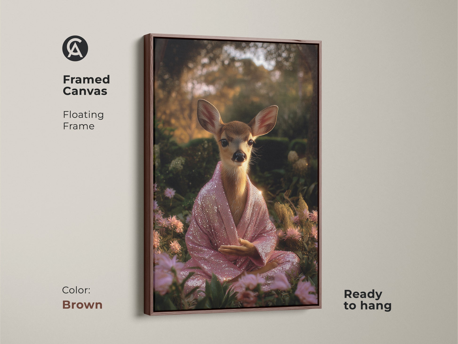 Brown framed canvas art featuring a meditating deer. The fawn is adorned with a pink sequin robe. This spiritual animal wall decor is ready to hang. The boho artwork brings peaceful nature vibes. It makes a unique housewarming gift.