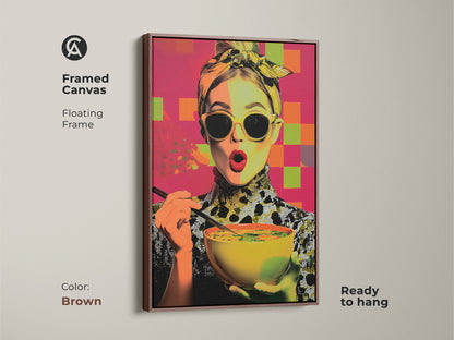 Framed canvas featuring a pop art woman with soup. The floating brown frame enhances this contemporary kitchen wall art. A foodie gift for her with yellow orange and pink abstract elements. This modern woman portrait is ready to hang. It's colorful kitchen decor.