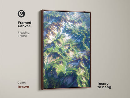 Framed canvas art with a brown floating frame. The artwork displays an aerial mountain landscape. This framed canvas is ready to hang. The brown frame complements the natural tones of the mountain scene. Add a touch of nature to your home decor with this piece.