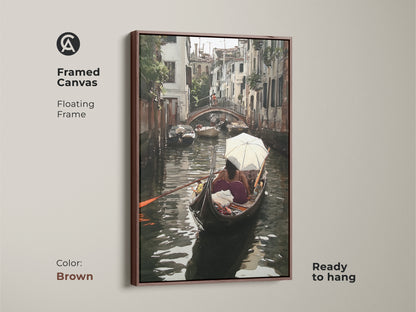 Framed canvas of a Venice canal watercolor art print. This Italian cityscape wall art boasts a floating brown frame and is ready to hang. The teal and brown artwork presents a gondola boat scene ideal for adding an artistic home accent.