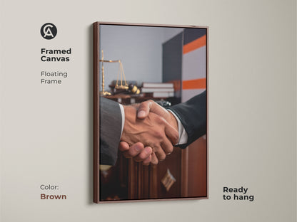 Framed canvas featuring handshake artwork perfect for a lawyer gift. Floating in a brown frame it showcases scales of justice. Ready to hang this contemporary office art symbolizes a business agreement. Ideal for legal offices this dark brown and grey art promotes partnership and trust. Elevate your professional space with this sophisticated office decor.