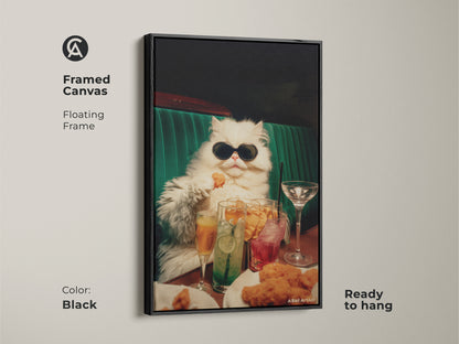 Framed canvas artwork of a persian cat in sunglasses. This floating frame is black. The art features the cat seated at a table. Drinks and chicken nuggets are also on the table. It is ready to hang.