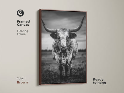 Framed canvas featuring a black and white Texas Longhorn in a floating brown frame. This ready-to-hang animal portrait canvas adds character to entryways living rooms or home offices. The rustic ranch decor complements farmhouse or minimalist interiors. It brings a touch of the wild west to any residential space making it an excellent housewarming gift.