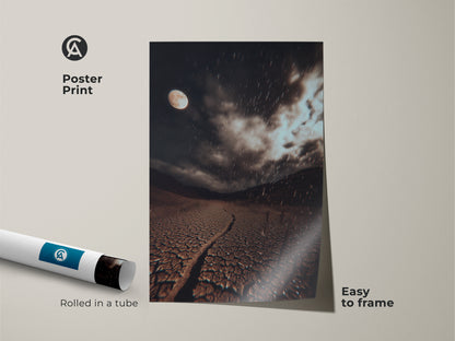 Poster Print of a dark brown cracked earth art. It features a surreal moonlit desert landscape. The grey atmospheric landscape wall art has a rainy night moon phase. It's easy to frame.