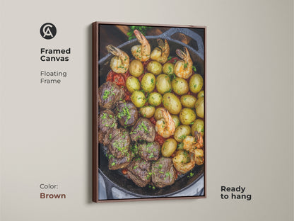 A framed canvas features a steak and shrimp skillet meal. The floating brown frame enhances this comfort food artwork. It adds a rustic farmhouse touch to any kitchen. This print is perfect as a housewarming gift for home cooks.