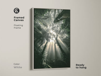 Framed canvas presenting deep green tropical foliage. White floating frame offers a clean modern look. Ready to hang. This emerald green bedroom artwork brings nature's beauty indoors. Perfect for boho decor.
