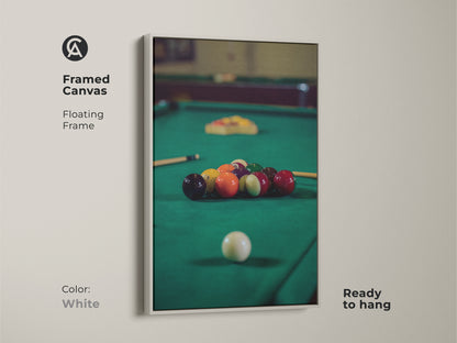 White framed canvas displays billiard balls on an emerald green pool table. This floating frame artwork is ready to hang adding a touch of leisure to your space. It's an ideal piece of sports wall art and gift for pool players.