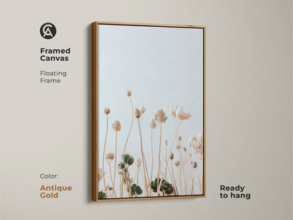 Framed canvas featuring light blue and cream wildflowers. The antique gold floating frame complements this minimalist botanical artwork. Perfect for adding a touch of nature to your bedroom decor. It is ready to hang. Ideal for plant lovers seeking a neutral boho art piece for their home.