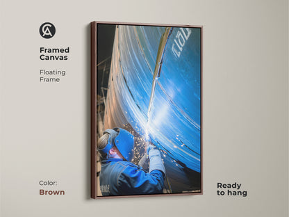 Realistic welder art in a brown floating frame. This industrial canvas art is ready to hang. The art captures the intense action of industrial welding. It is a thoughtful gift for tradespeople.