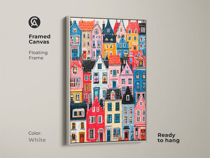 Framed canvas showcasing colorful houses art. It has a white floating frame. The artwork is ready to hang. This vibrant cityscape print is a clean and modern addition to your decor. Art for any room.