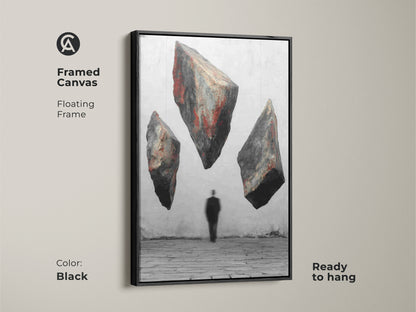 Black framed canvas art showcases surreal floating rocks and a man silhouette. This conceptual art wall art features a red black gray abstract. Its floating frame adds a modern touch. Ready to hang for a minimalist surrealism aesthetic. A perfect office wall decoration and fine art print abstract.