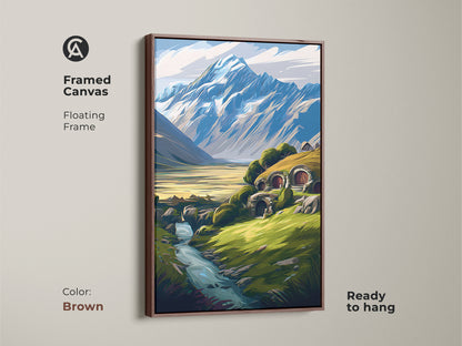 Framed canvas print of a fantasy hobbit hole landscape with a floating brown frame. The mountain and river scene is ready to hang. A cozy nature inspired wall decor.
