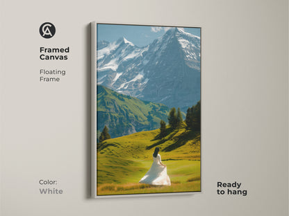 A framed canvas showcases a snowy mountain landscape. A woman in a white dress adds a touch of elegance. The floating frame is white. This wall art is ready to hang. Bring nature indoors with this beautiful and ethereal nature wall hanging. It is ideal as contemporary home art.