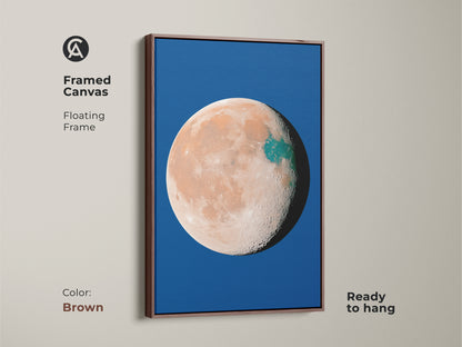 Framed canvas with abstract planet artwork floating in a brown frame. The celestial moon decor features a deep blue background. Orange teal space wall art adds a surreal minimalist touch. Ready to hang.