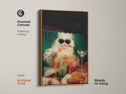 Framed canvas artwork of a persian cat in sunglasses. The floating frame is antique gold. The cat is seated at a table filled with drinks and chicken nuggets. This funny art is ready to hang in your home.
