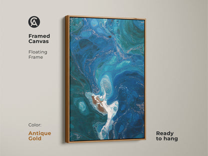 Framed canvas print of deep blue fluid art. Antique gold floating frame enhances the ocean swirl wall hanging. Perfect for contemporary coastal decor. This unique fluid art gift is ready to hang and adds a touch of elegance.