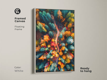 Framed canvas print of a colorful autumn forest. The aerial view artwork is showcased in a white floating frame. The bright white frame complements the vibrant colors of the forest. This canvas is ready to hang and adds a touch of nature.