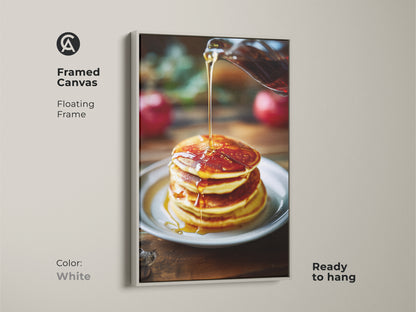 Framed canvas art of pancakes with golden syrup. The floating frame in white offers a clean look to the food photography. It's ready to hang and perfect for kitchen decor. The amber and golden yellow hues brighten any space. Great for breakfast nooks.