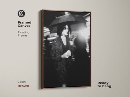 Elevate your decor with this framed canvas art. The brown floating frame enhances this black and white artwork. This street photography print arrives ready to hang. Showcase a woman with an umbrella. It adds urban chic to your home. This makes a sophisticated addition for any space.