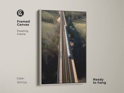 Adorn your walls with this framed canvas art. It features a modern aerial train bridge. The floating frame adds a contemporary touch. This art piece is ready to hang. It enhances any room. The realistic transportation artwork is set in a white frame.